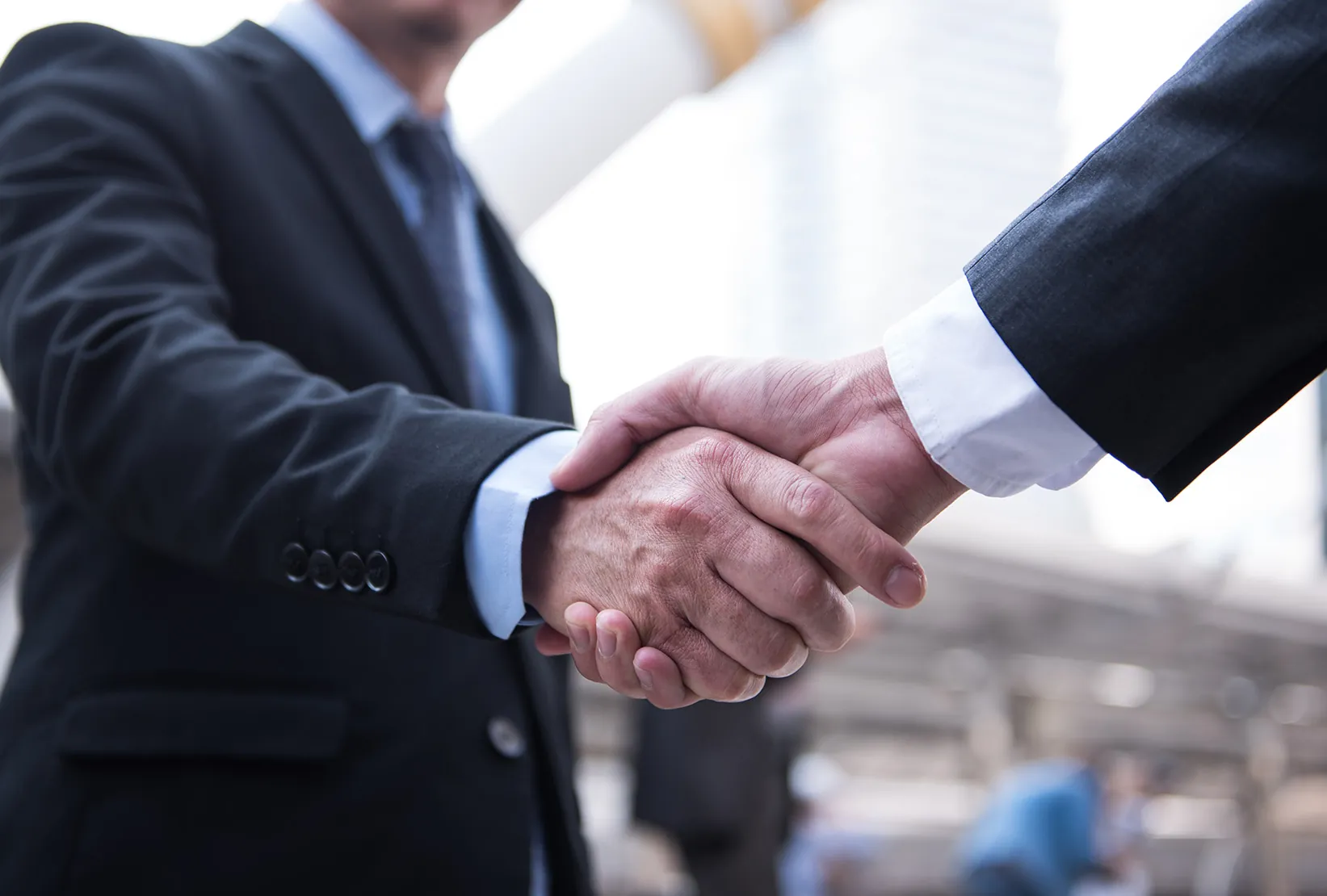 Business handshake representing Syncology’s commitment to school management excellence and client success.