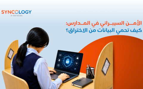 طالبة تجلس على مكتب دراسي وتعمل على جهاز لابتوب يعرض درع أمان رقمي مضاء لتوضيح مفهوم الأمن السيبراني في المدارس.
